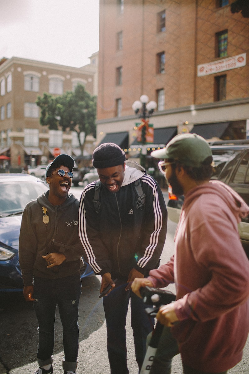 Photo by Jed Villejo three men in jacket laughing at each other