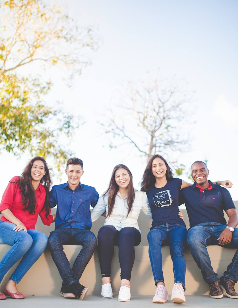 Photo by Naassom Azevedo group of people sitting on bench near trees duting daytime